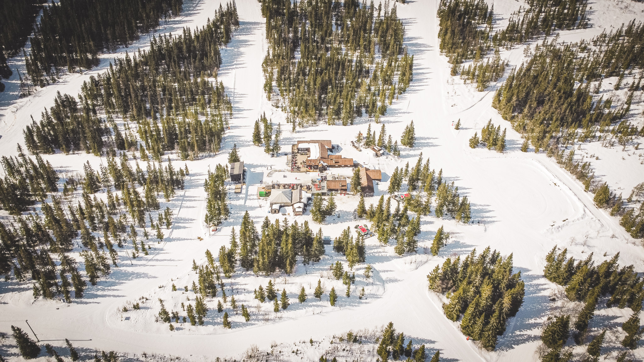 Flyfoto av Knettsetra midt i det snødekte Trysilfjellet, omgitt av granskog