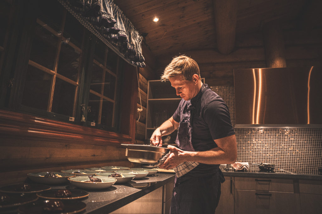 Kokk tilbereder mat i rustikt kjøkken